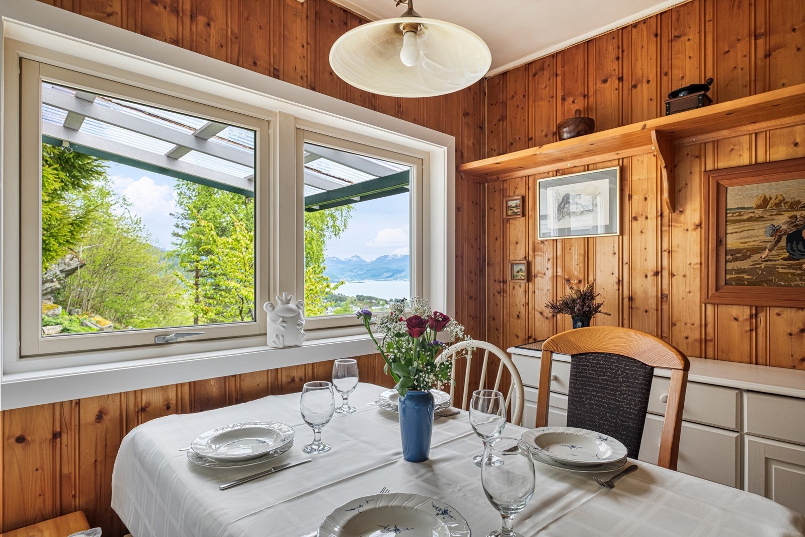 Fra spiseplassen kan man nyte utsikt til natur og fjell gjennom store vinduer. Galleribilde