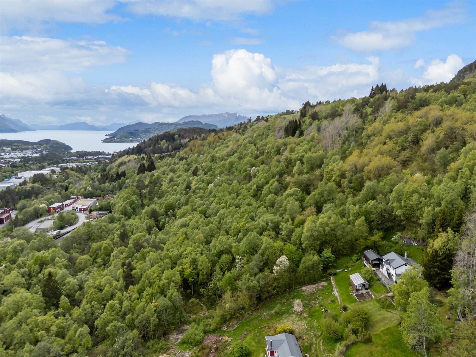 Eiendommen ligger tilbaketrukket i en frodig fjellside, omgitt av skog og med utsikt mot fjorden. Galleribilde