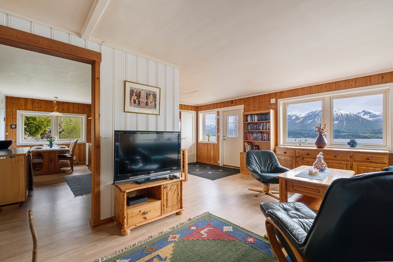 Store vindusflater i stuen gir utsikt til fjell og natur, samtidig som de slipper inn mye lys. Galleribilde