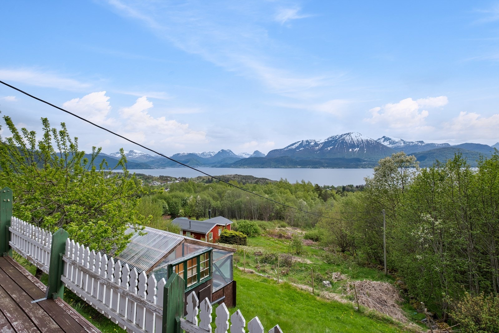 Eiendommen inkluderer et velholdt uteområde med plen, steinpartier og et uthus. Galleribilde