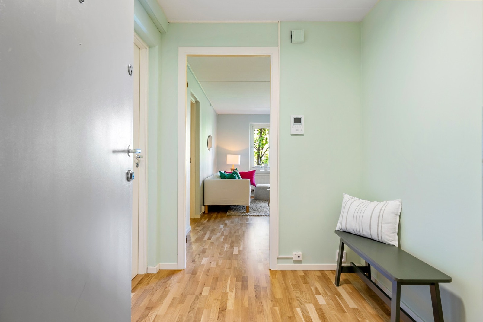 Entréen har god plass til oppbevaring av yttertøy og sko. Lyse overflater og parkett på gulv bidrar til en luftig romfølelse allerede fra du kommer inn døren. Galleribilde