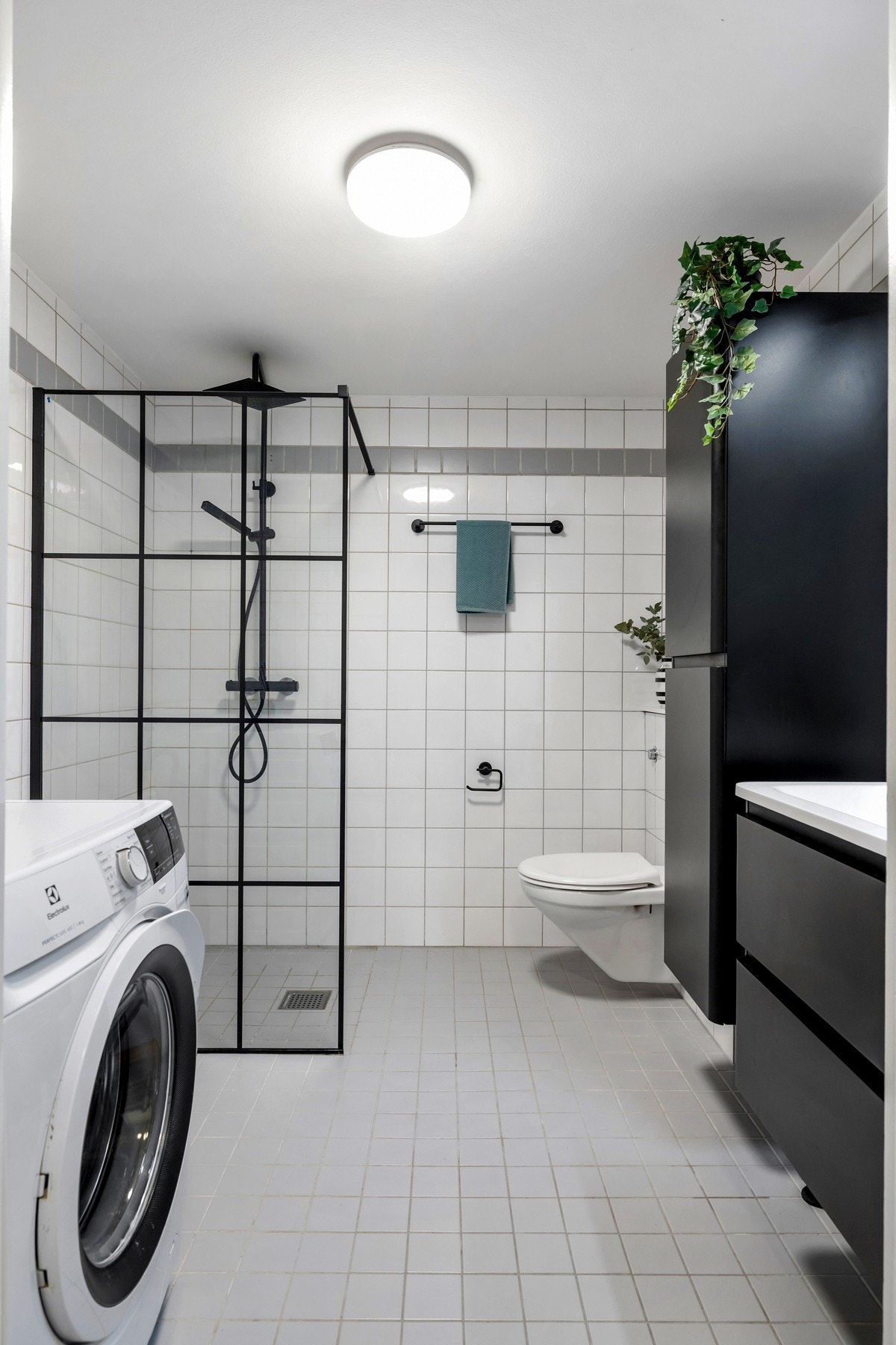Badet er flislagt og har en praktisk utforming med god plass til oppbevaring. Det er opplegg for vaskemaskin. Galleribilde