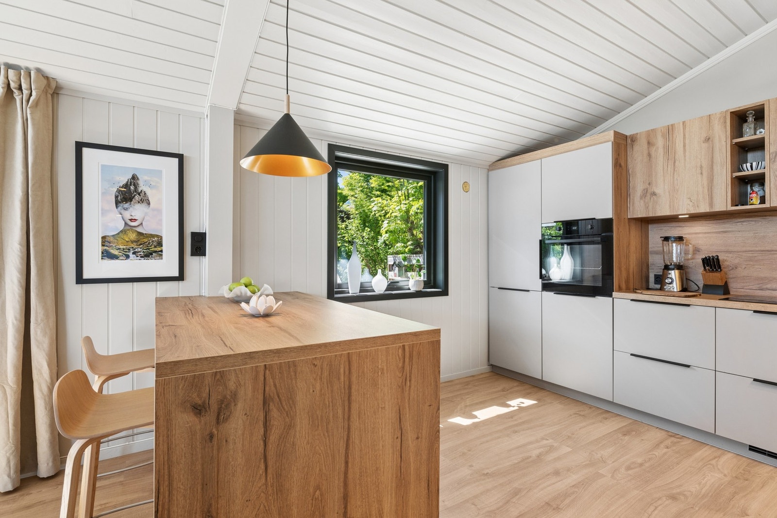 Moderne kjøkken med god benkeplass og praktisk kjøkkenøy som et naturlig sosialt samlingspunkt... Galleribilde