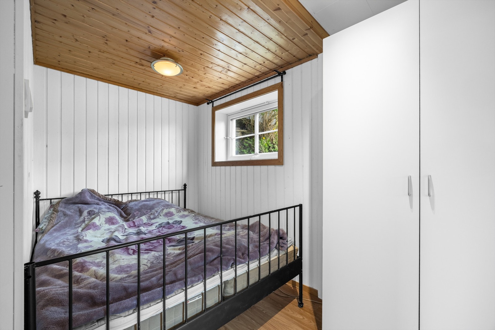 Koselig soverom i underetasjen med tretak, vindu mot hagen og innebygd garderobe - et rolig og privat rom med god oppbevaringsplass. (Dette rommet er ikke godkjent til varig opphold og ikke søkt omgjøring til hoveddel fra tilleggsdel) Galleribilde