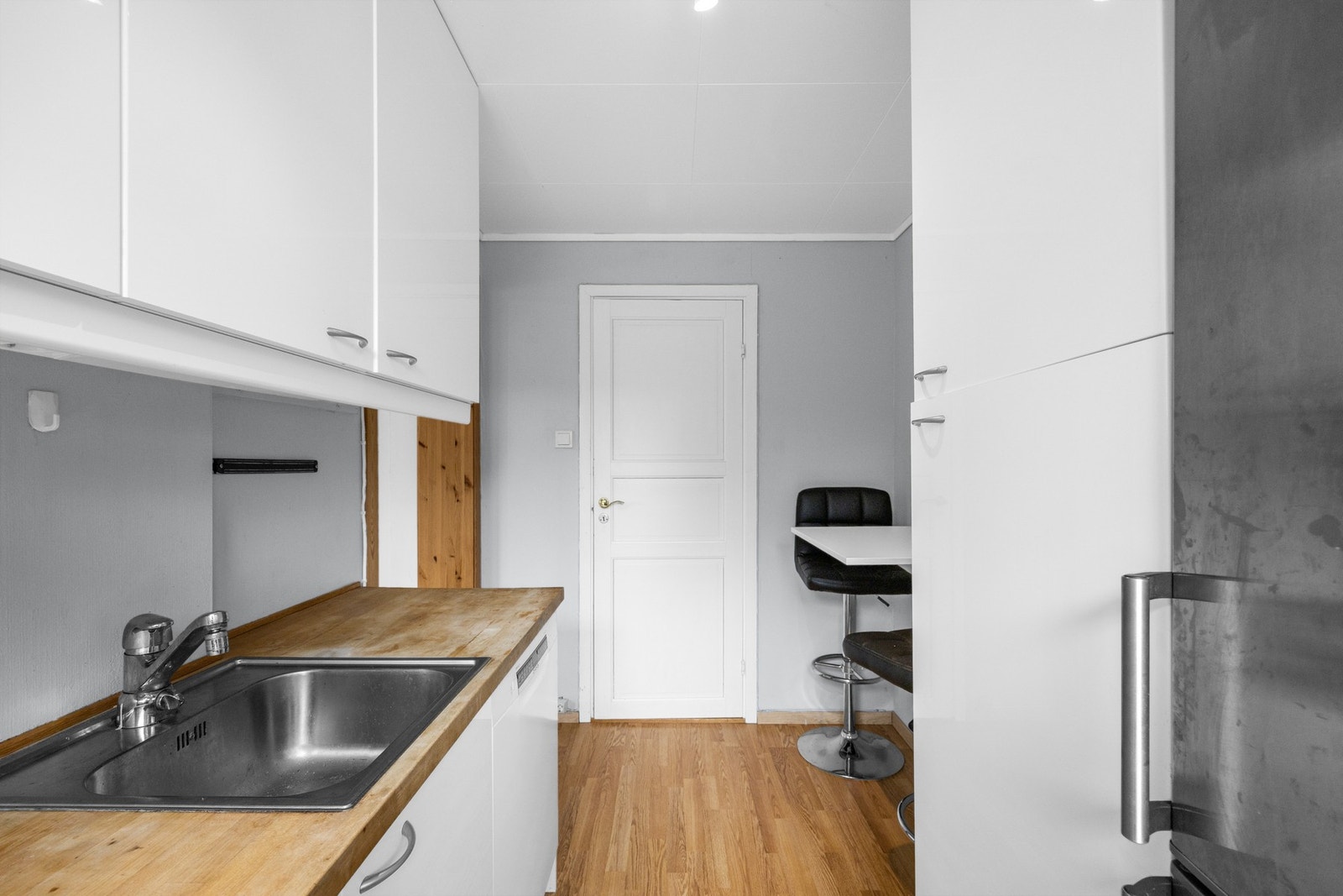 Funksjonsrikt kjøkken med hvite glatte fronter og benkeplate i heltre - med kjøl/fryseskap, komfyr med platetopp og kjøkkenventilator med kullfilter. (Dette rommet er ikke godkjent til varig opphold og ikke søkt omgjøring til hoveddel fra tilleggsdel) Galleribilde