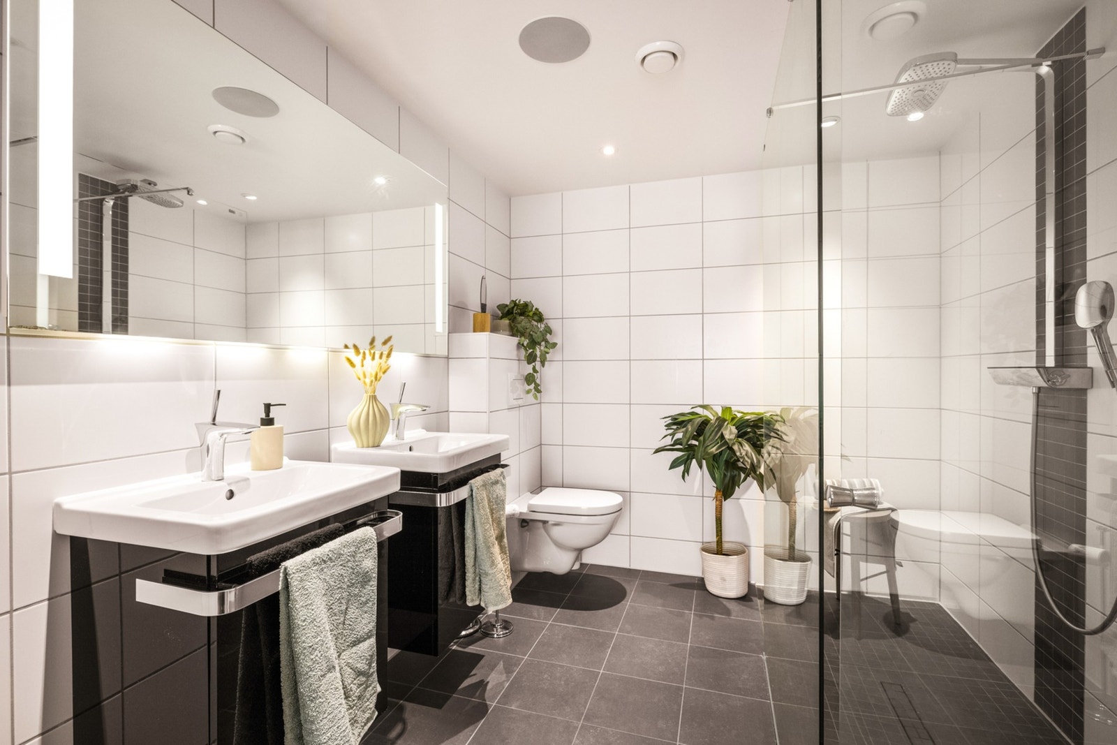 Badet inneholder dobbel servant med møblement/speil og belysning,
vegghengt toalett, dusjvegg i glass, innfelbar dusjdør i glass,
og dusjgarnityr. Galleribilde
