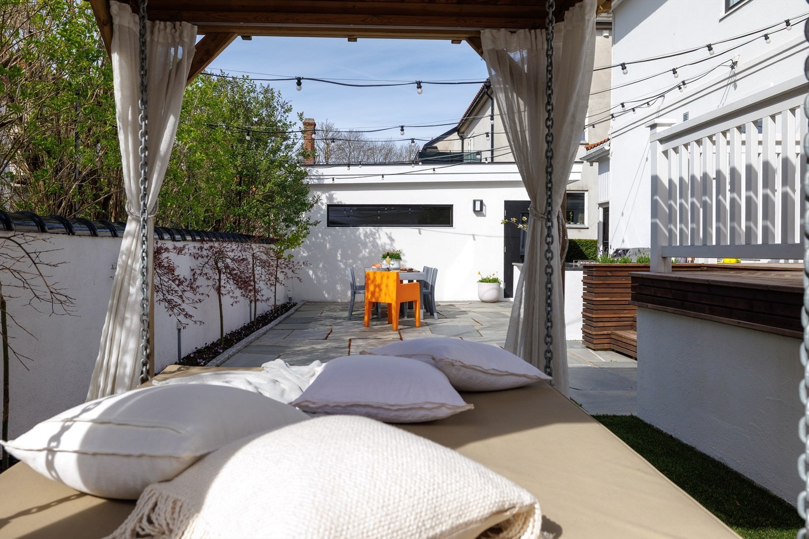 Uteområdene har mange soner. Både i form av takterrasse, steinlagt plattinger og pergola som denne. Varige materialer og stilren utforming. Galleribilde