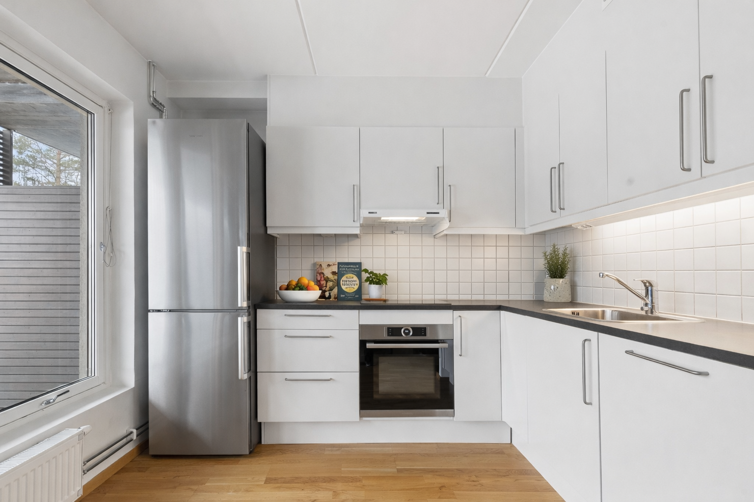 Kjøkkenet har en tidløs innredning med glatte fronter og laminert benkeplate. Det er medfølgende hvitevarer. Bildet er digialt møblert via AI. Galleribilde