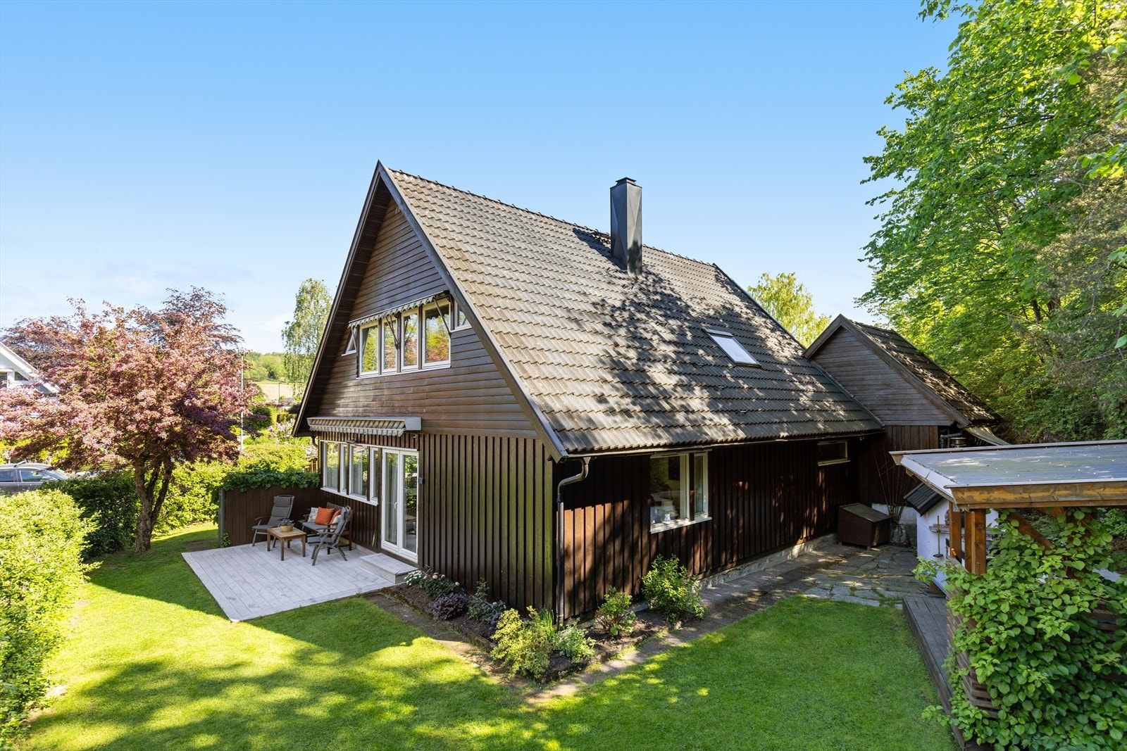 Hagen er usjenert og solfylt hele dagen, dette er tatt tidlig på morningen. Hagestuen ligger til høyre i bildet. Galleribilde