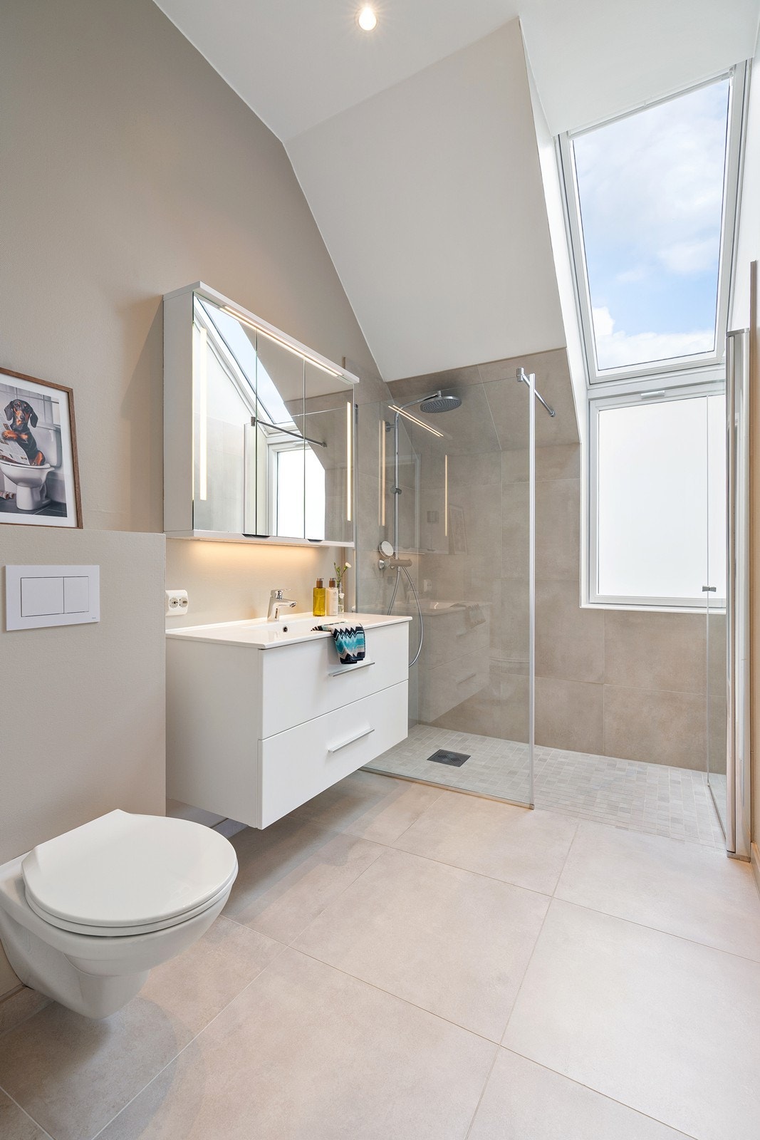 Delikat bad med store fliser, god takhøyde og flott lysinnslipp fra takvindu. Badet har dusjnisje med glassvegger og moderne innredning med god oppbevaringsplass Galleribilde