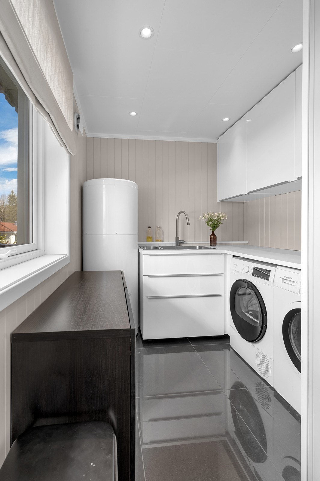 Vaskerommet er innredet med laminat benkeplate og praktisk opplegg for vaskemaskin. Galleribilde
