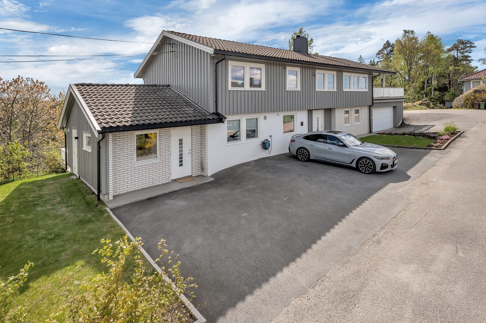 Romslig gårdsplass med flere parkeringsplasser og integrert garasje. Galleribilde