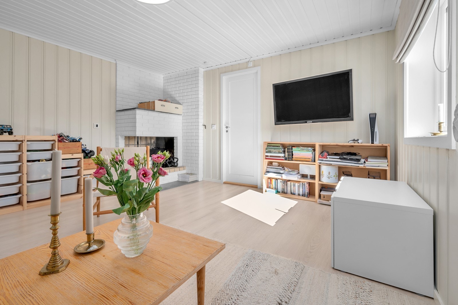 Stuen i boligen har peis med elektrisk oppvarming som supplement. Galleribilde