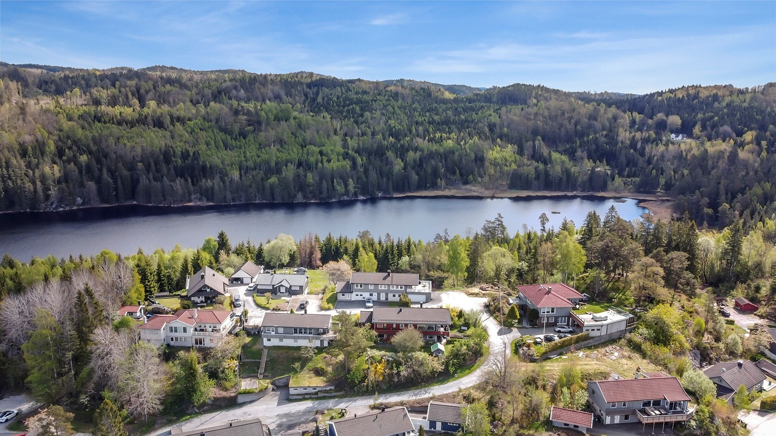 Boligen ligger i et naturskjønt område med utsikt mot vann og skog. Galleribilde