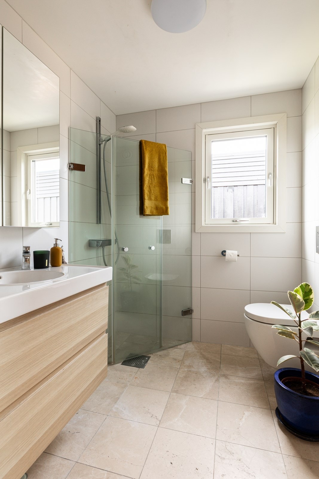 Badet består av servant med skuffer, dusjhjørne og vegghengt toalett. Galleribilde