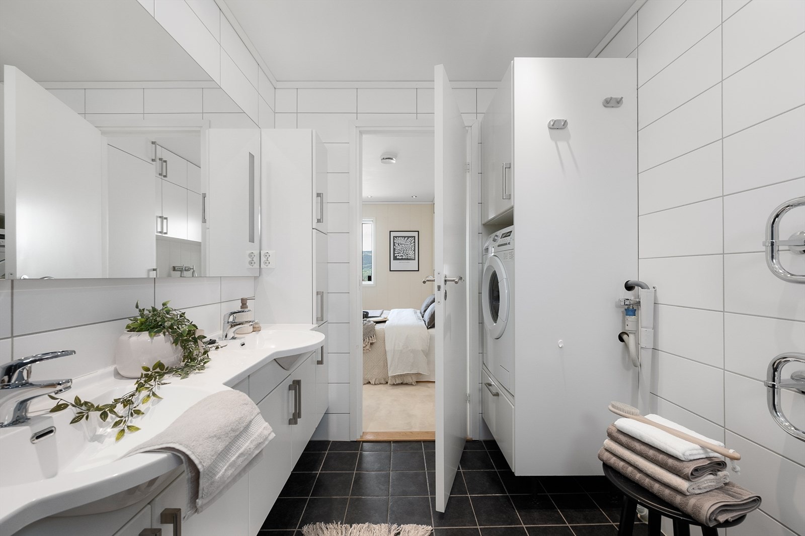 Badet har opplegg for vaskemaskin, dusjhjørne med glassdører og elektrisk håndkletørker. Galleribilde