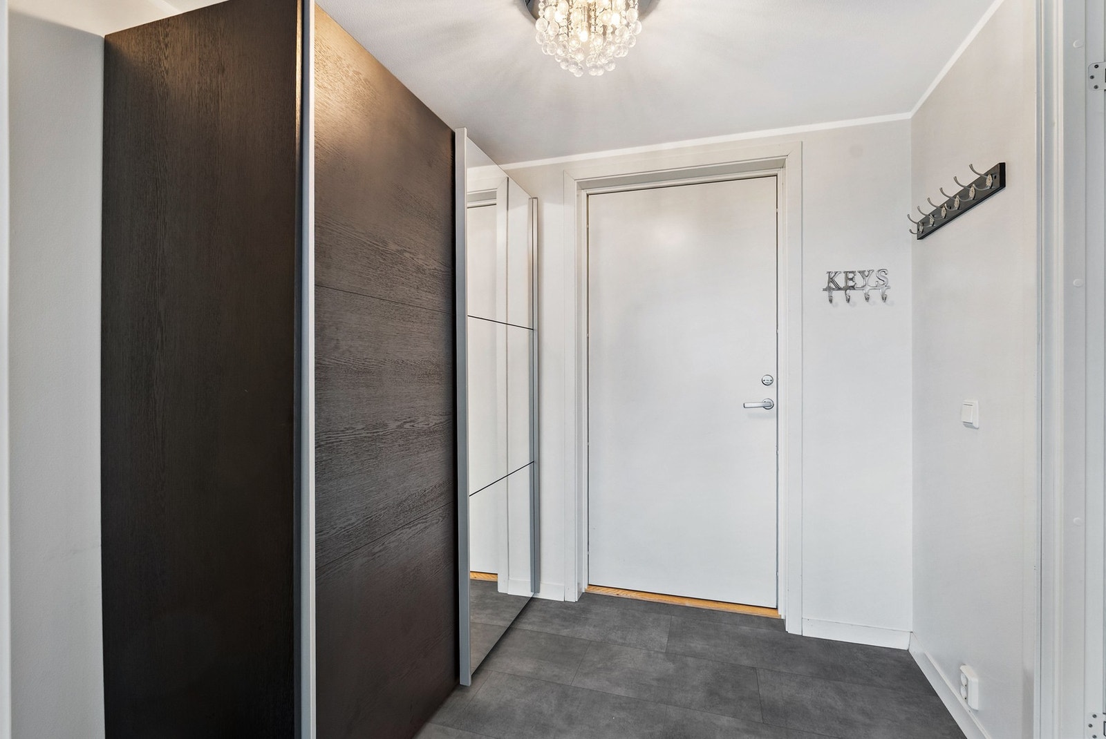 God plass til oppbevaring av yttertøy i en stor skyvedørsgarderobe med speilfronter. Galleribilde