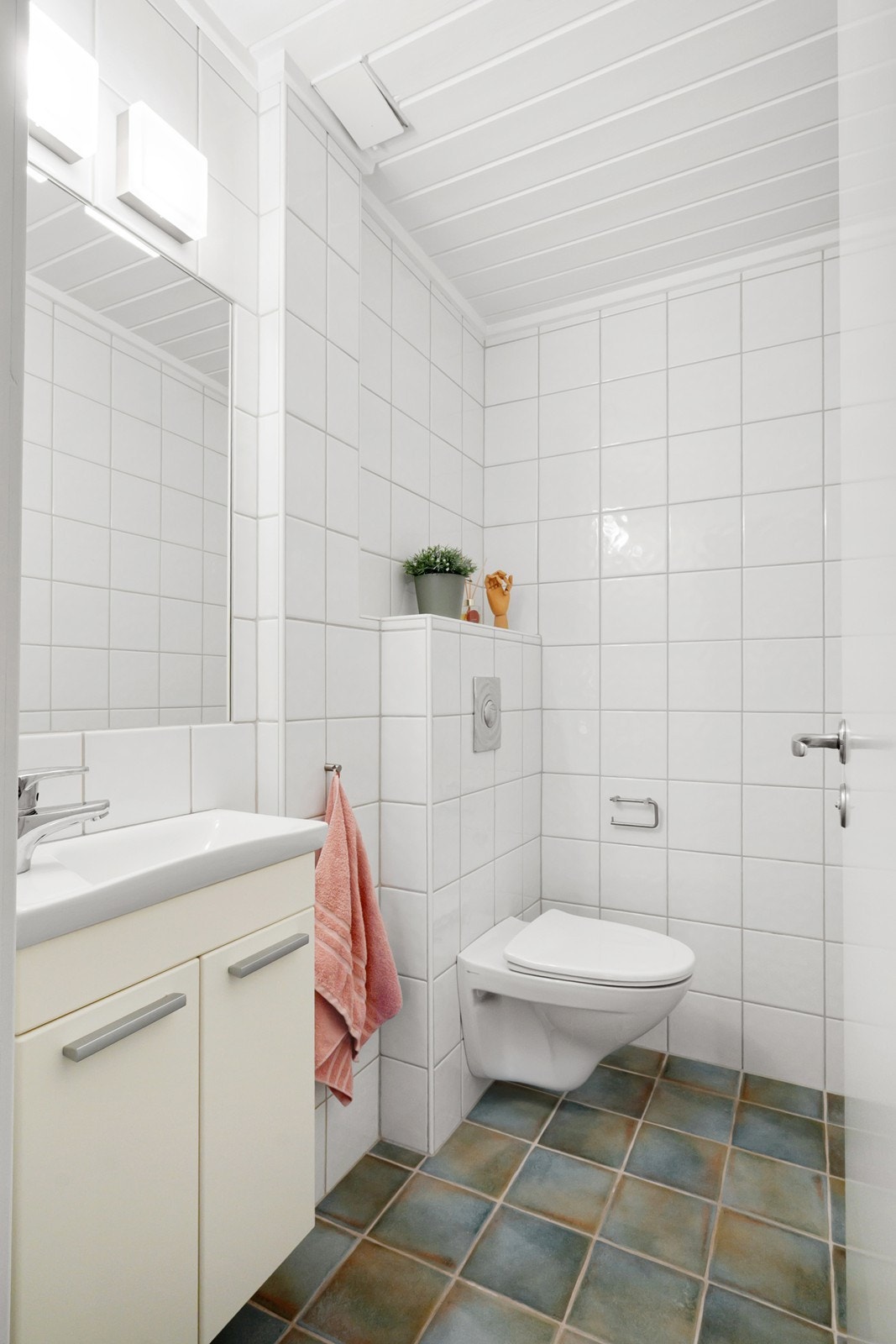 Toalettrom fra 2006 ligger ved siden av badet, med samme fliser, varmekabler og enkel innredning. Galleribilde