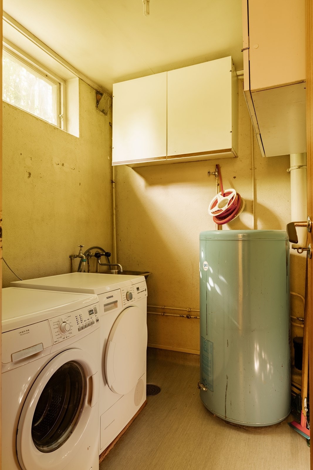Ved siden av badet ligger et vaskerom med opplegg for vaskemaskin og tørketrommel samt utslagsvask. Varmtvannsberederen er plassert i dette rommet, et rom de fleste familier drømmer om, men som ofte er glemt i nyere boliger. Galleribilde