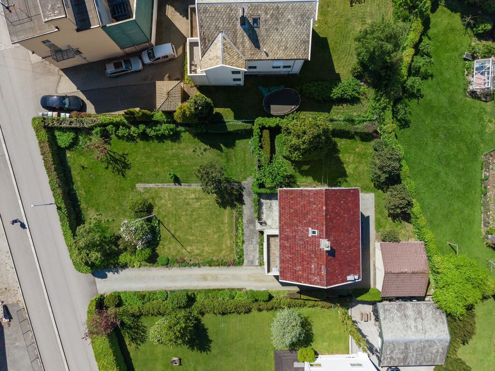 Tomten er pent opparbeidet med plen, hekk og diverse beplantning som rammer inn eiendommen. Galleribilde