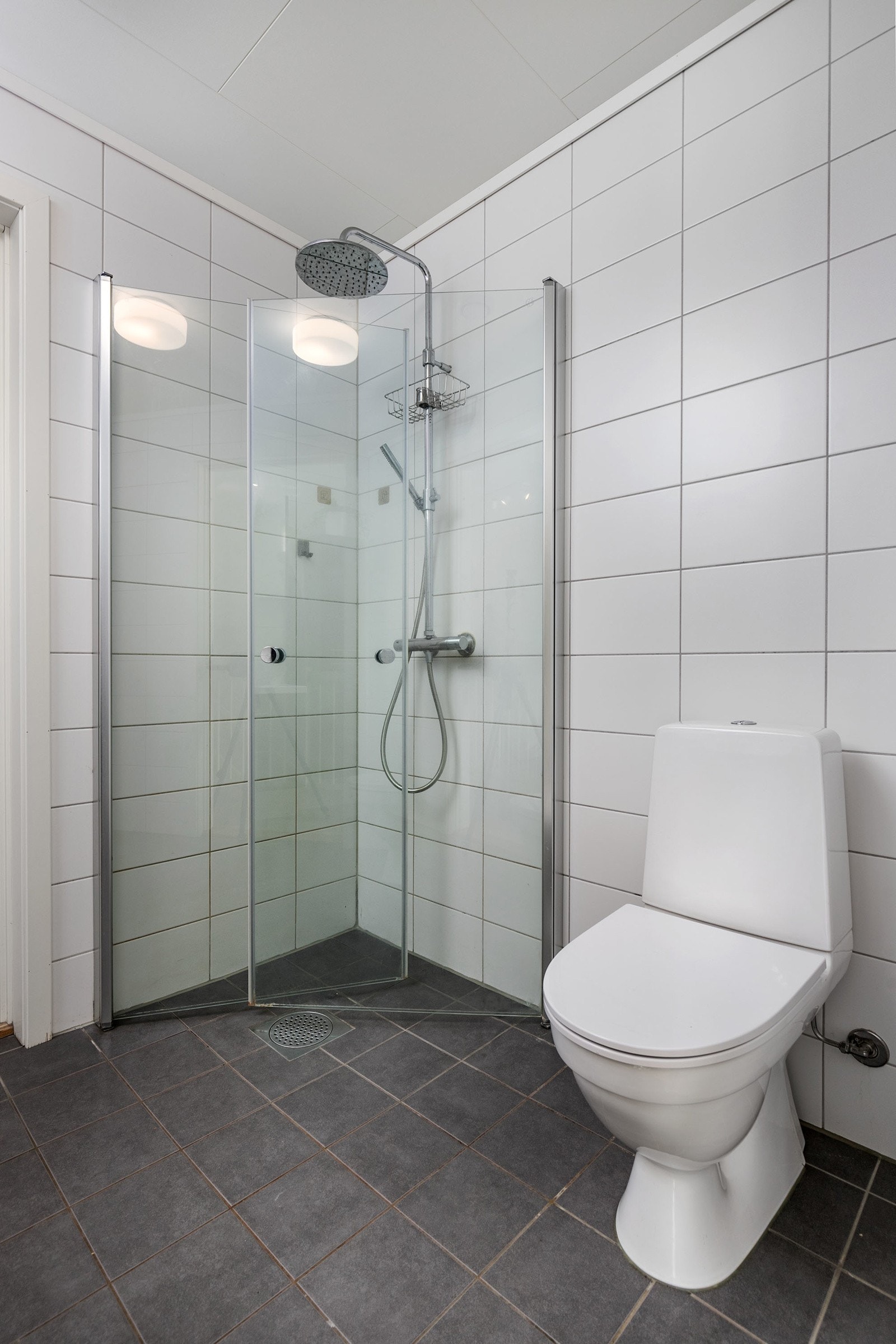 Innredningen på badet består av moderne skuffeinnredning med servant, samt speil over servant. Videre har badet dusjhjørne med innfellbare dører og gulvstående toalett. Galleribilde
