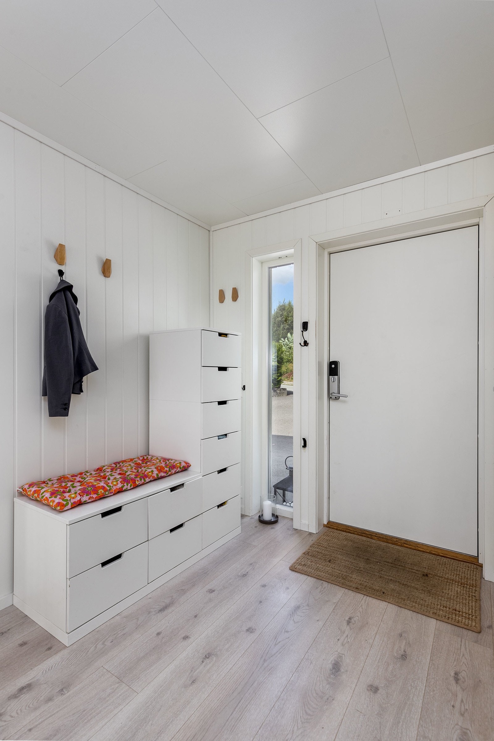 Flott entré med laminat gulv og lysmalte veggflater. Avsatt plass til skap. En flott trapp sørger for å ta deg raskt mellom etasjene i boligen. Inngangsdør med dørkodelås. Galleribilde