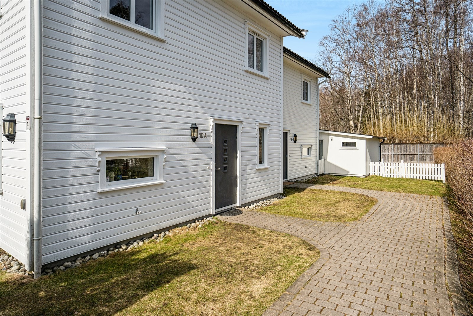 Boligen har et hyggelig inngangsparti via stensatt internvei som er felles med naboen. Galleribilde