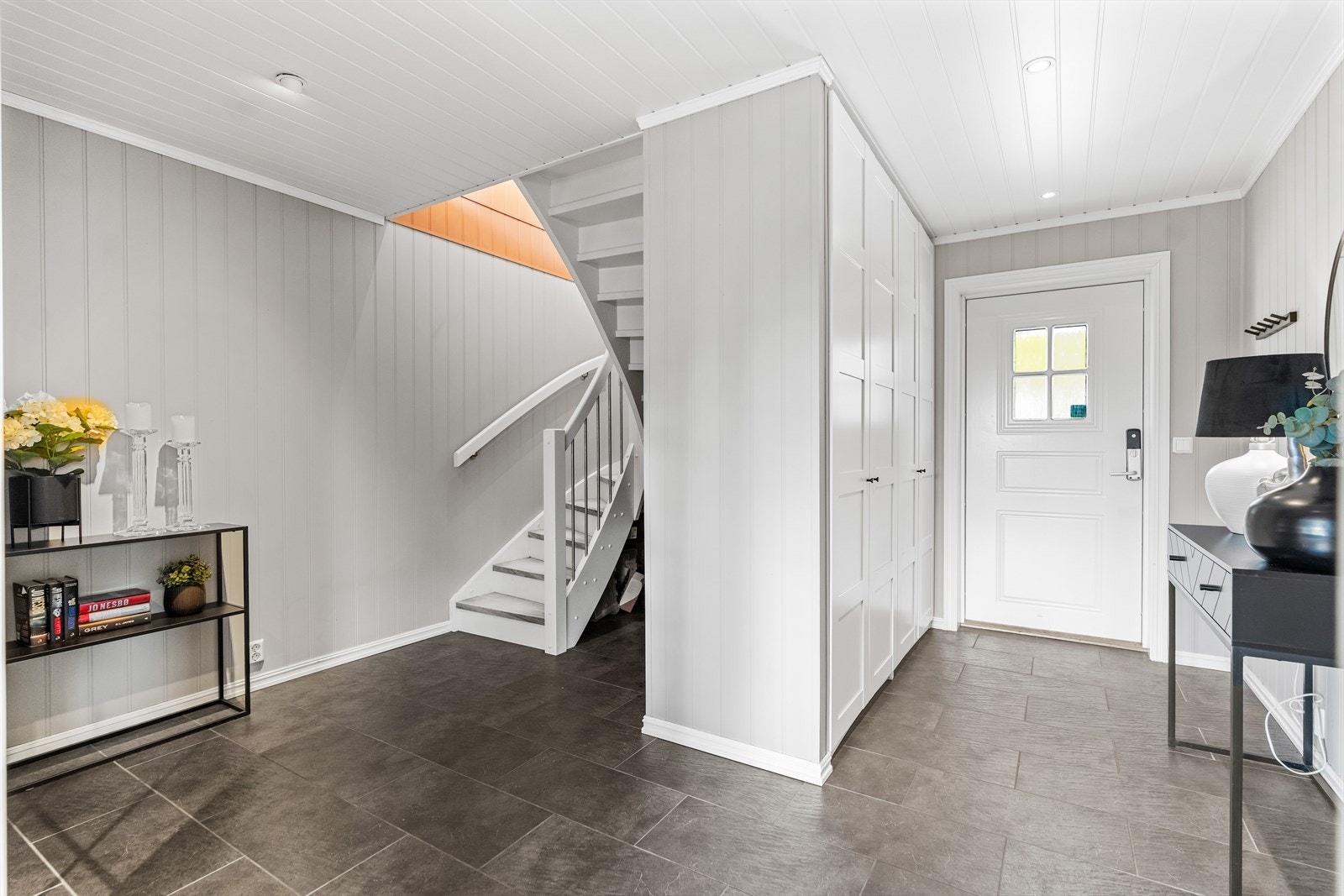 Vel inne er det en fin entré med lysmalt panel på veggene, downlights i himlingen og grå gulvfliser med vannbåren gulvvarme. Galleribilde