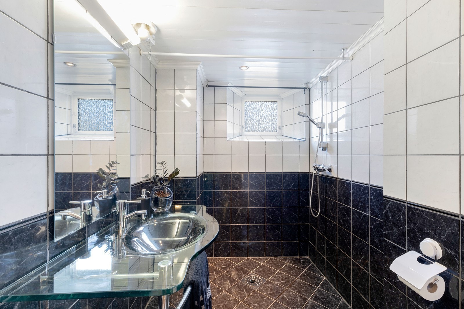 Romslig flislagt bad med dusj, wc og varmekabler. Her er det også opplegg til vaskemaskin og tørketrommel. Galleribilde