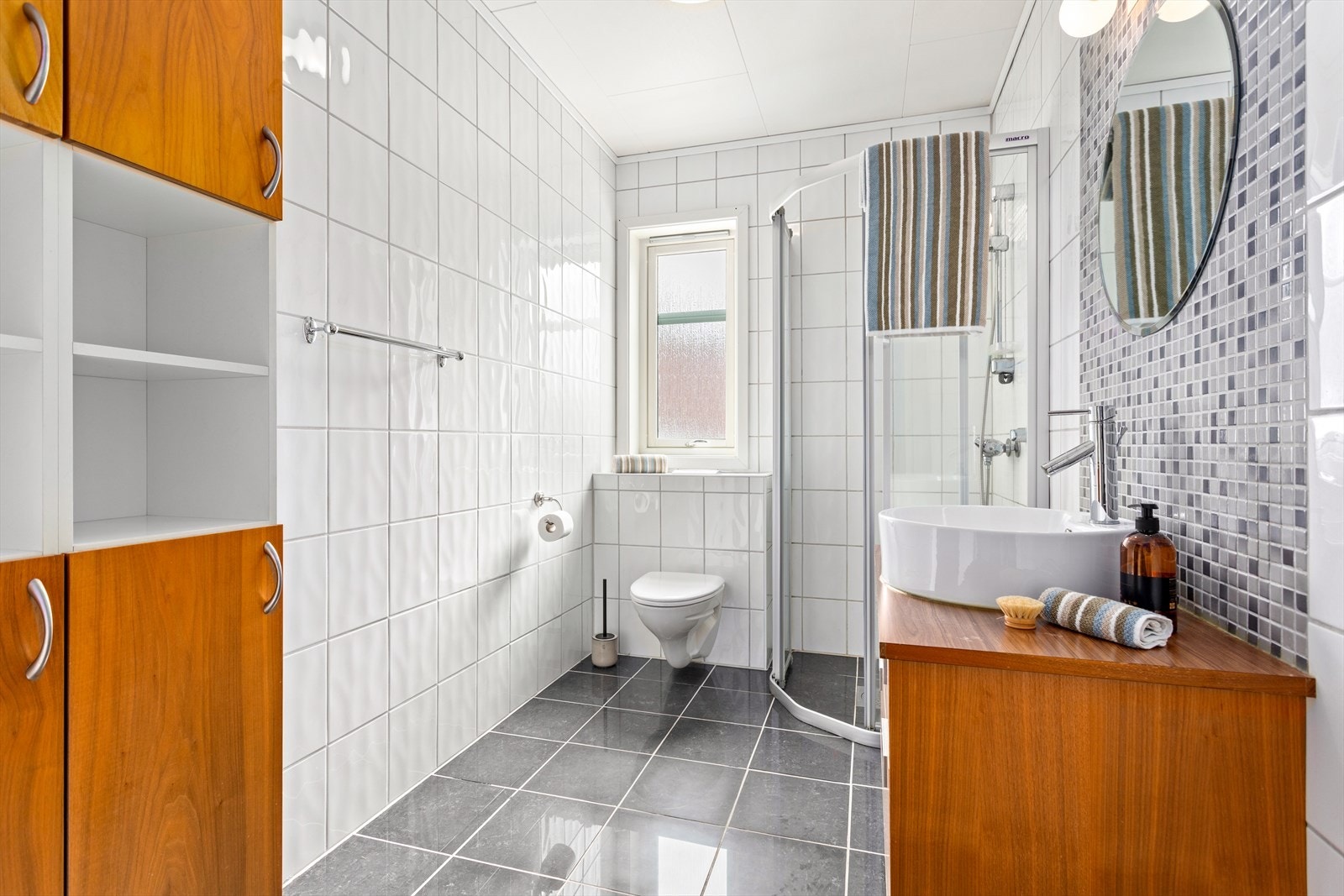 Badet har flis på veggar og golv. I taket er det plater. Galleribilde