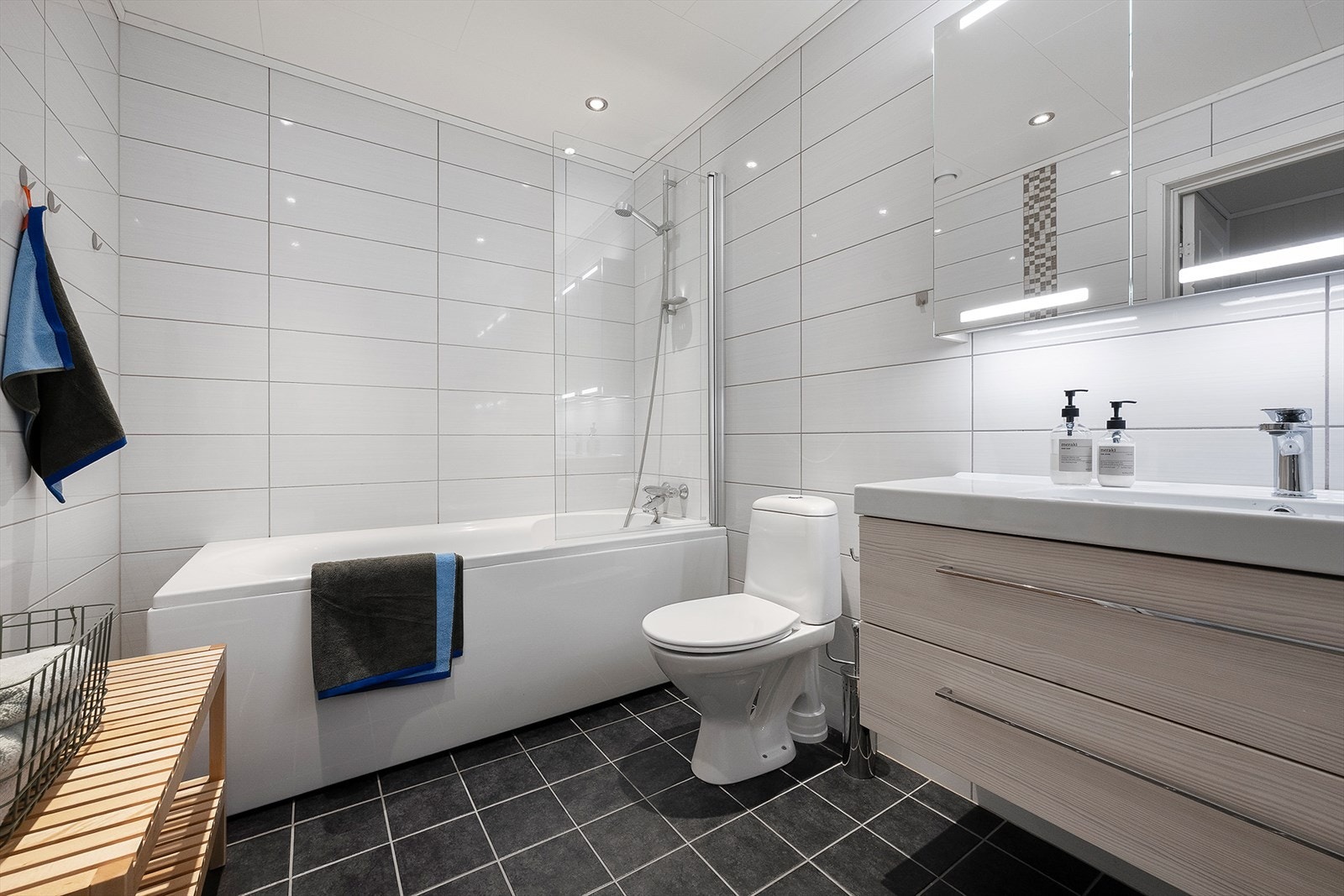 Badet er utstyrt med baderomsmøbel med heldekkende servant, speilskap, badekar m/dusjvegg og toalett. Galleribilde