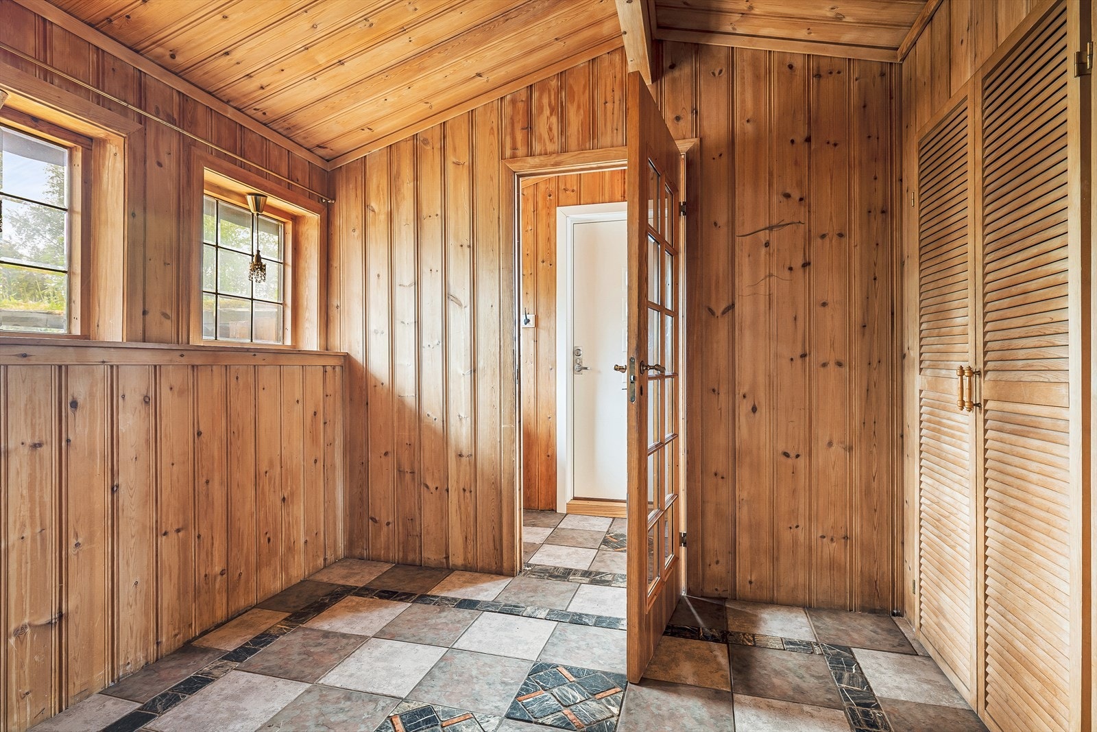 Entré i hoveddelen med keramiske fliser på gulvet og panel på vegger og i himling. Galleribilde