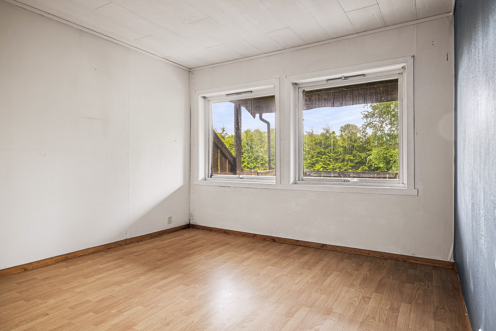 Soverom i første etasje med laminat på gulvet og malt strie på veggene. Galleribilde