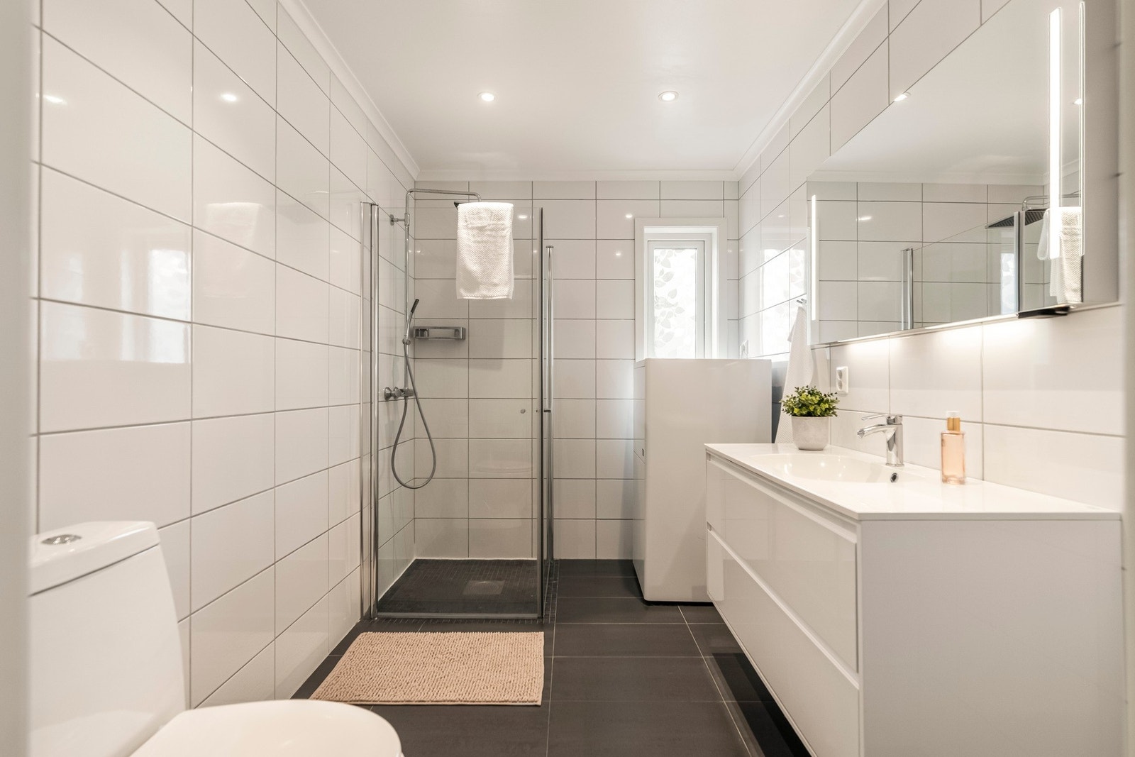 Lyst og funksjonelt bad med dusjsone og god plass. Hvite flater gir et rent og tidløst uttrykk. Galleribilde