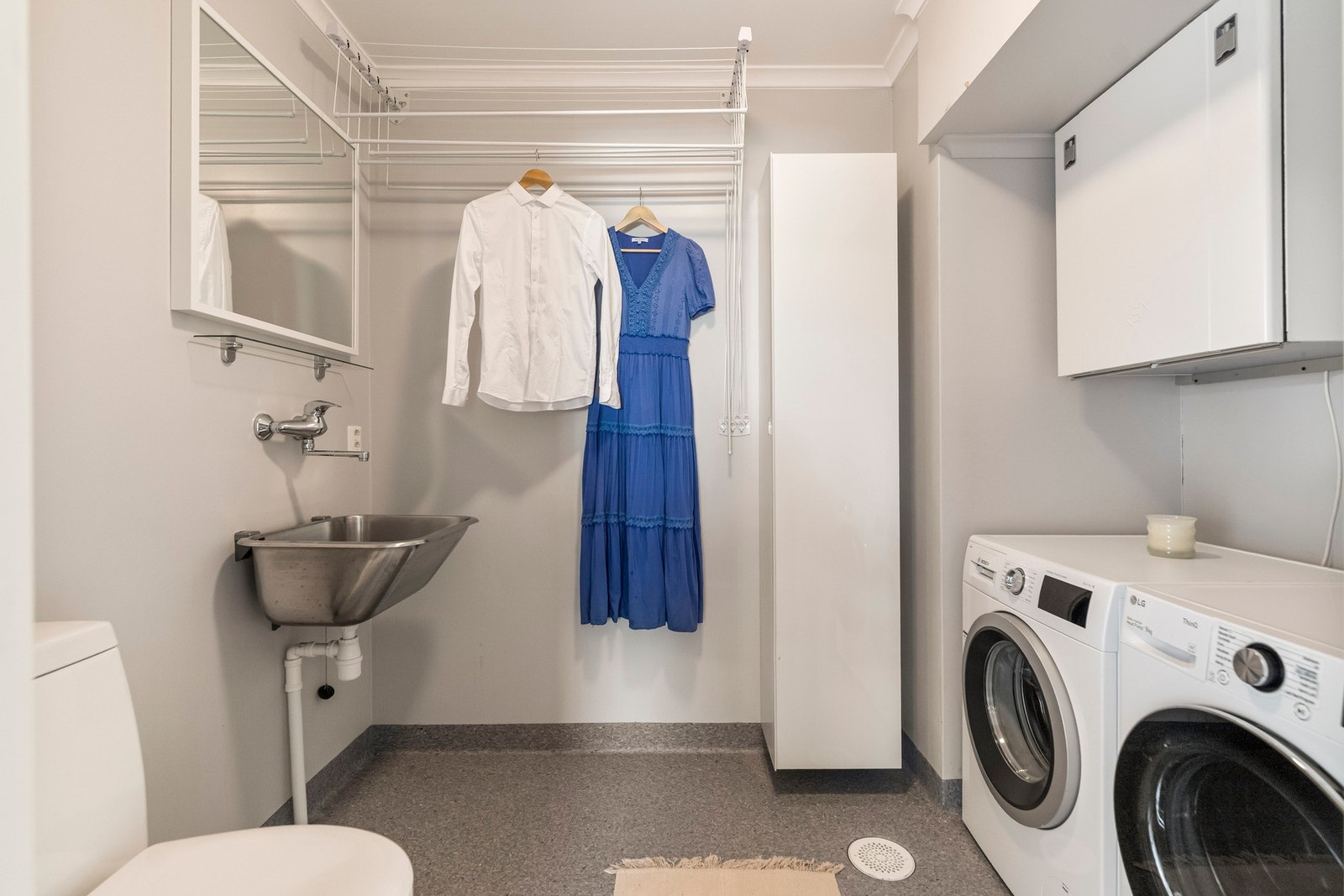 Praktisk vaskerom med servant, vaskemaskin og god oppbevaringsplass. Sotluke til pipe er plassert her - alt samlet på ett sted. Galleribilde