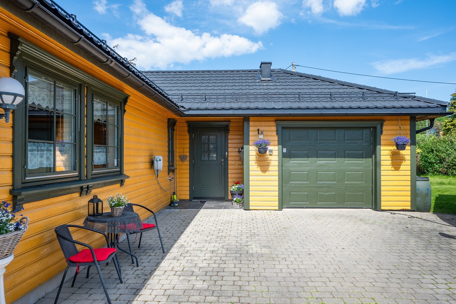 Parkering gjøres enkelt på den steinbelagte gårdsplassen eller i integrert garasje med direkte adkomst. Galleribilde