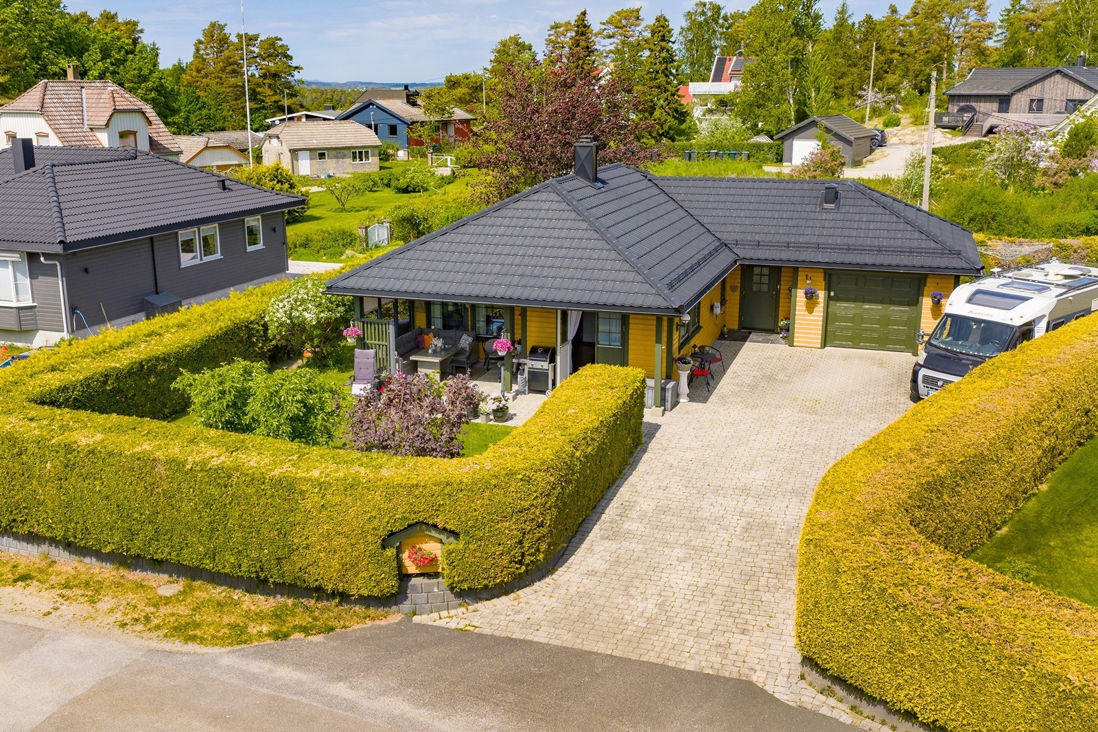 Boligen fra 2002 fremstår velholdt og innbydende, omgitt av en skjermet og velstelt tomt med pent opparbeidede uteområder. Galleribilde
