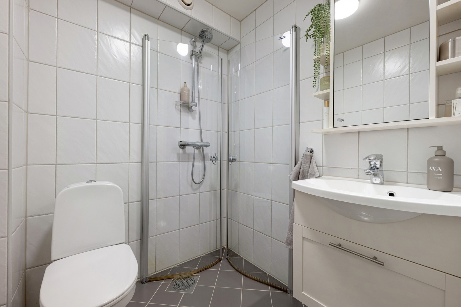 Det andre badet i etasjen har dusjhjørne, servantinnredning og gulvmontert toalett. Praktisk løsning for en travel familiehverdag. Galleribilde