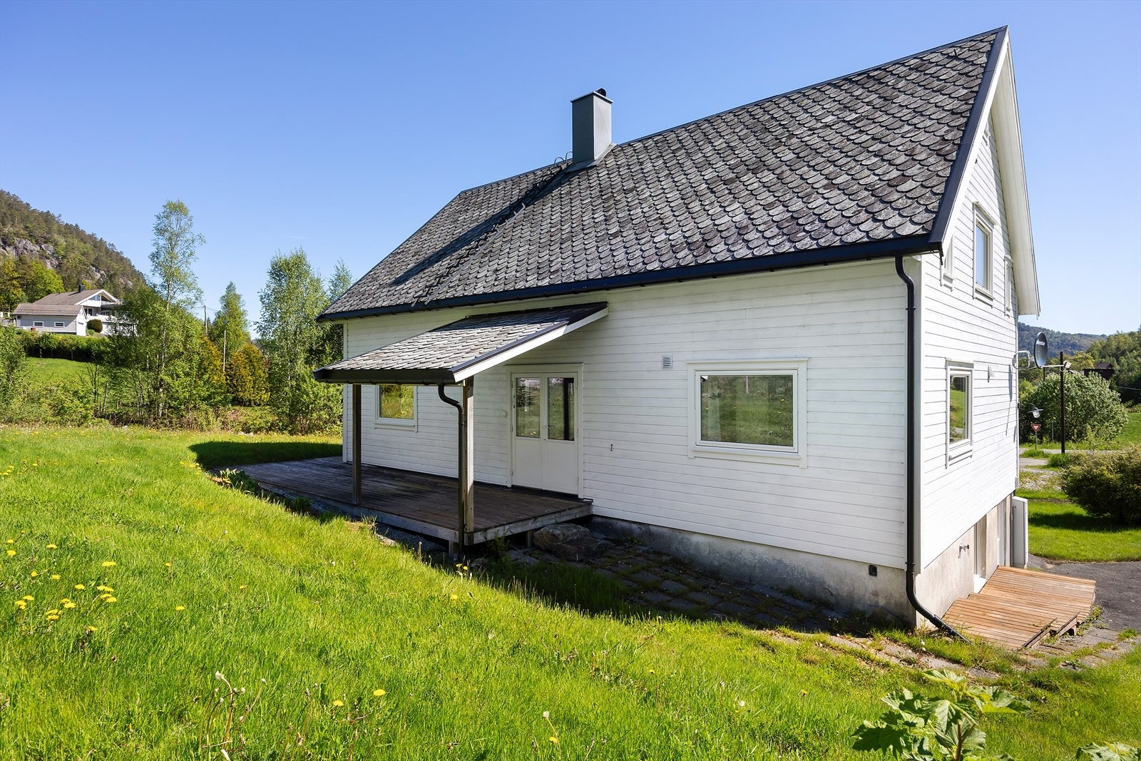 Våningshuset har en tradisjonell stil, med takrenner i sortlakkert aluminium fra 2022. Galleribilde