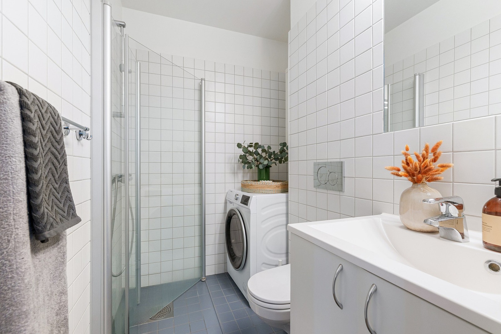 Badet er utstyrt med vegghengt toalett, dusjhjørne og servantinnredning Galleribilde