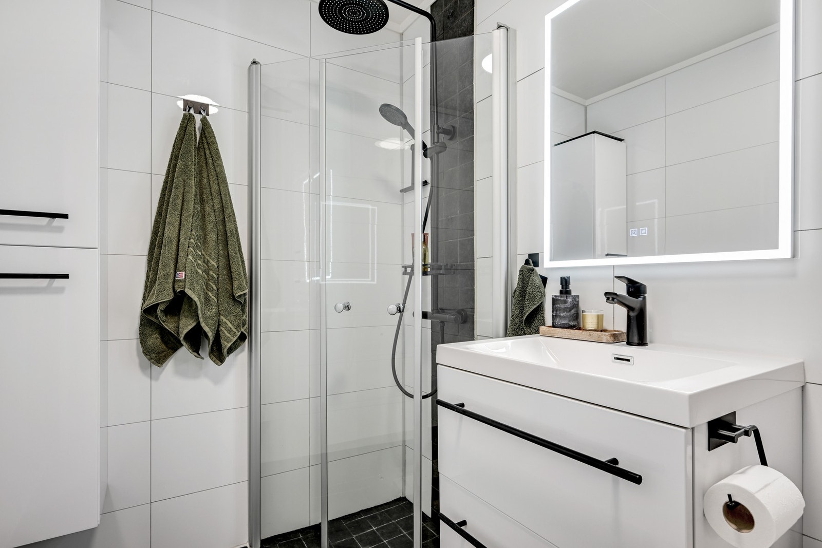 Badet fremstår som praktisk med vegghengt speil med belysning og antidugg Galleribilde