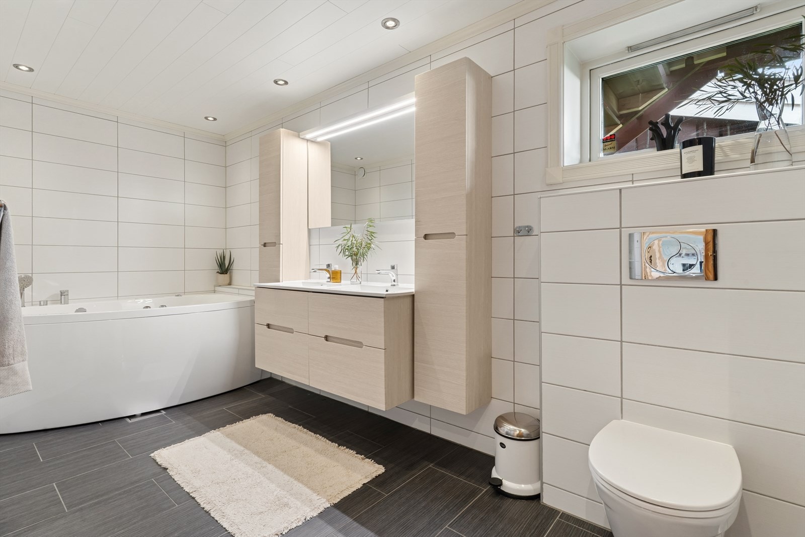 Flislagt og delikat hovedbad med badekar, dusj, vask med skapinnredning og vegghengt WC. Badet er fra 2013. Galleribilde