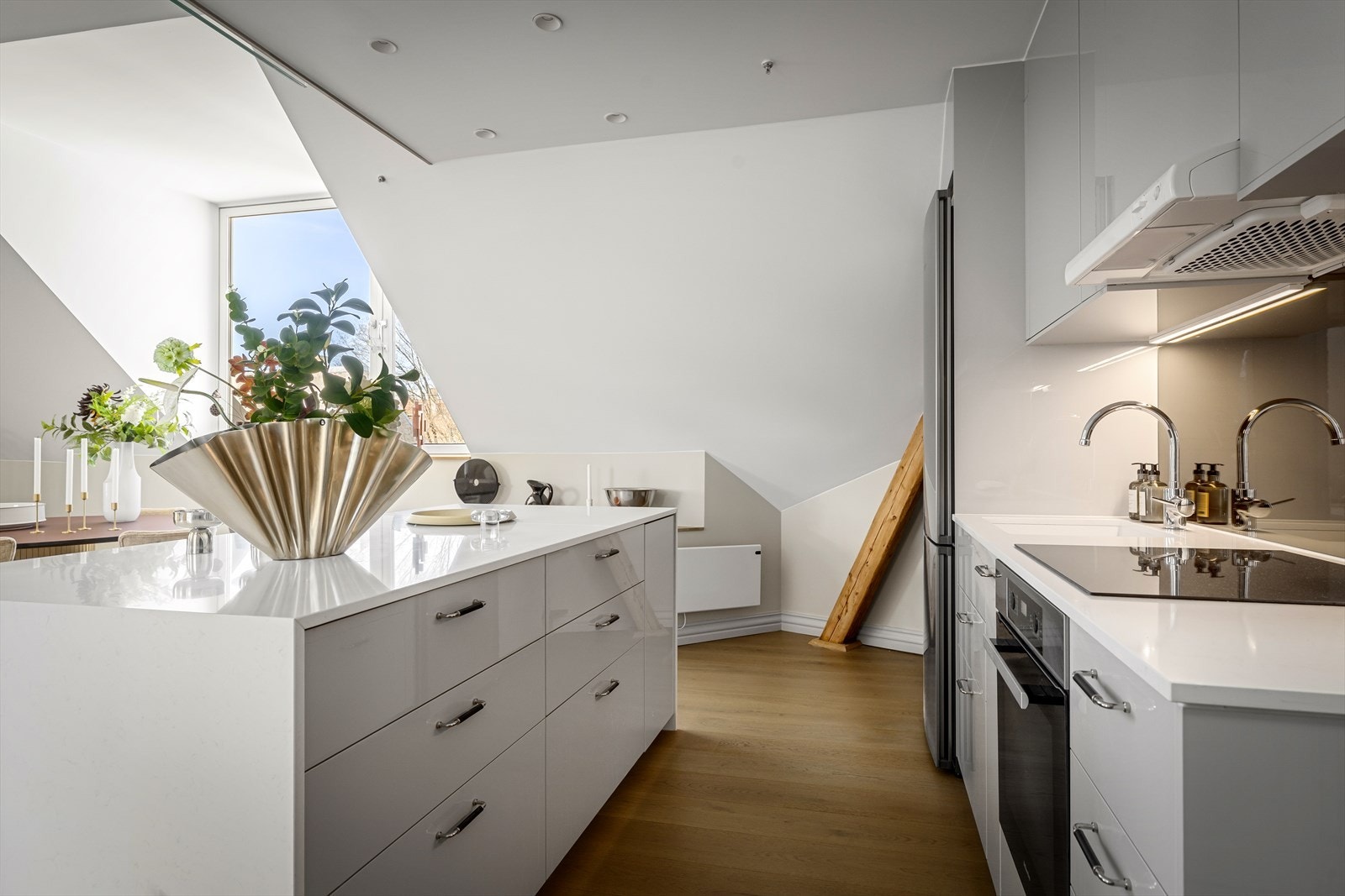 Kjøkkeninnredning med glatte fronter, komposittbenkeplate og integrerte hvitevarer. Galleribilde