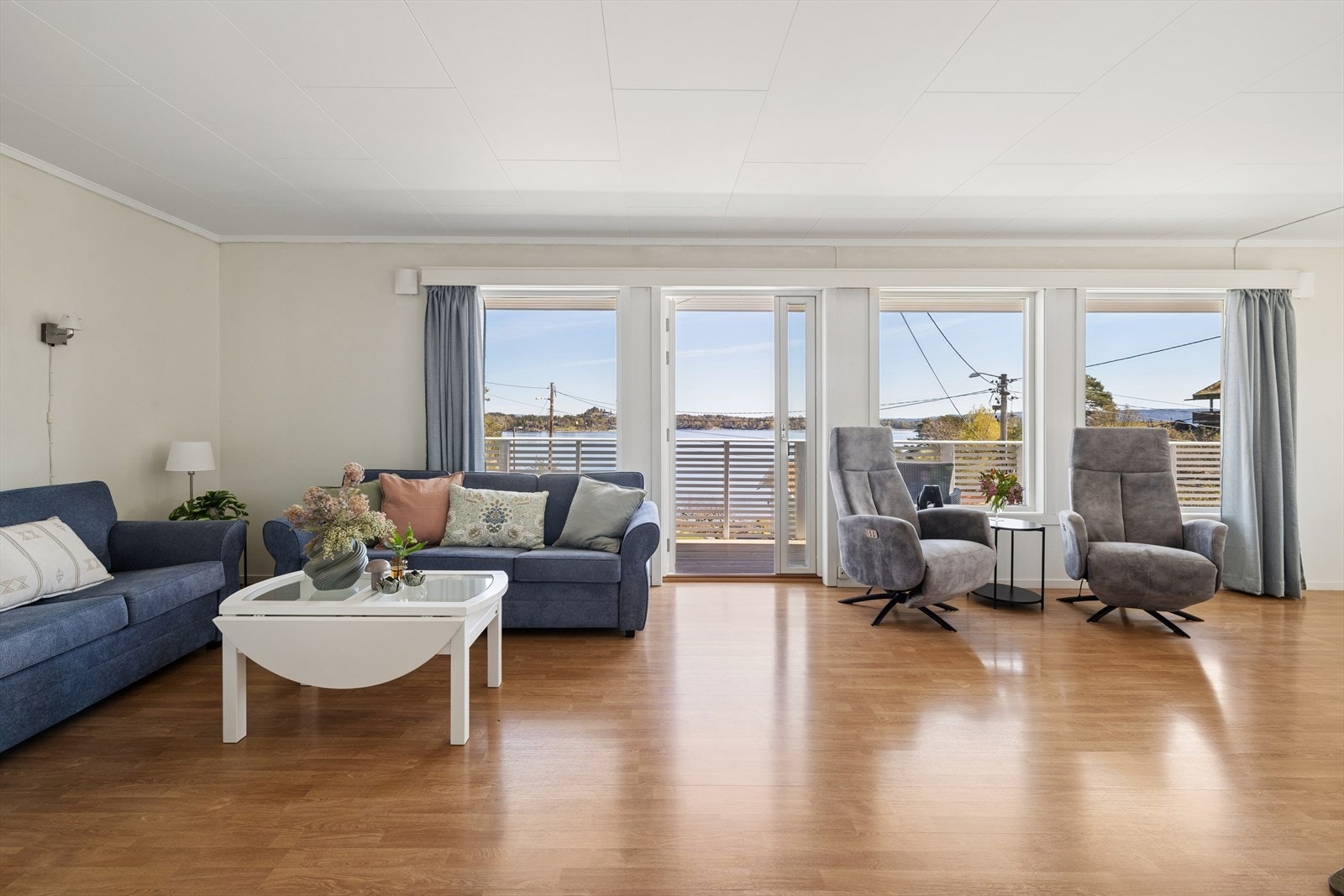 Romslig stue med store vindusflater og direkte utgang til terrasse Galleribilde