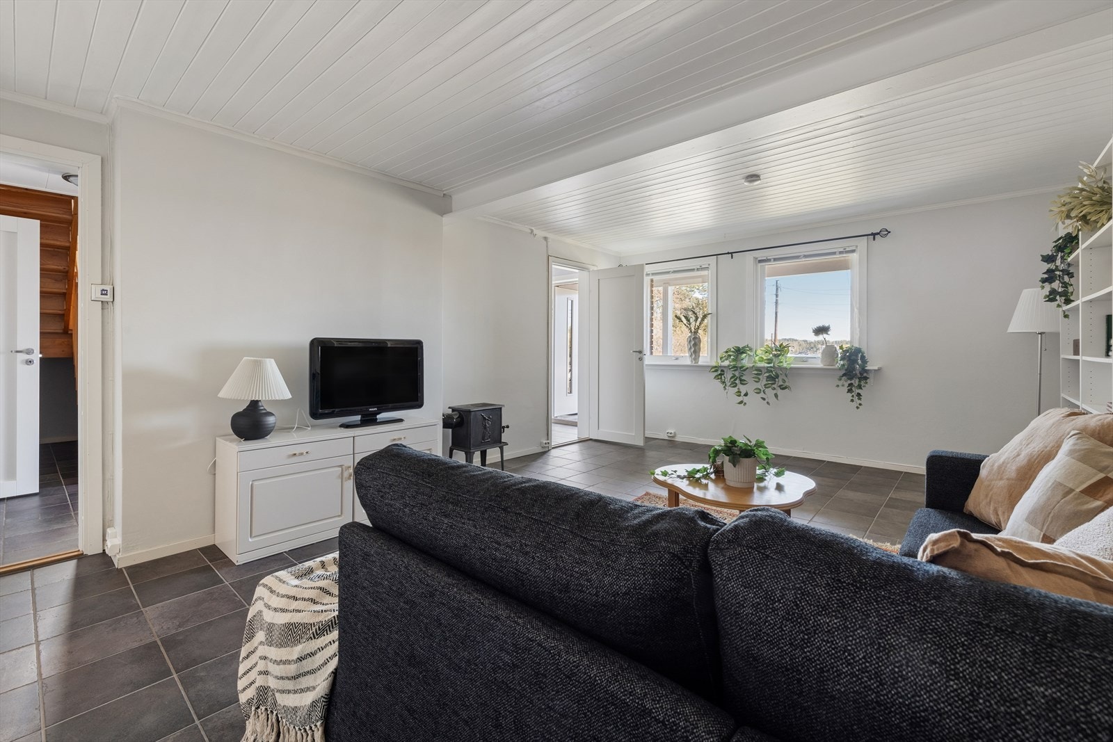 Kjellerstue i underetasjen med vedovn og direkte utgang til veranda. Galleribilde