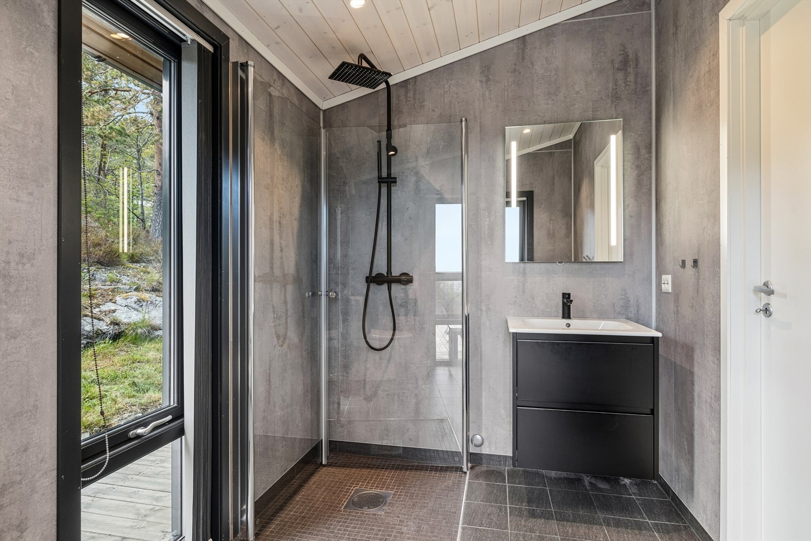 Badet er fra 2022 og har baderomsplater på veggene, fliser på gulvet og dusjnisje med glassdører. Galleribilde
