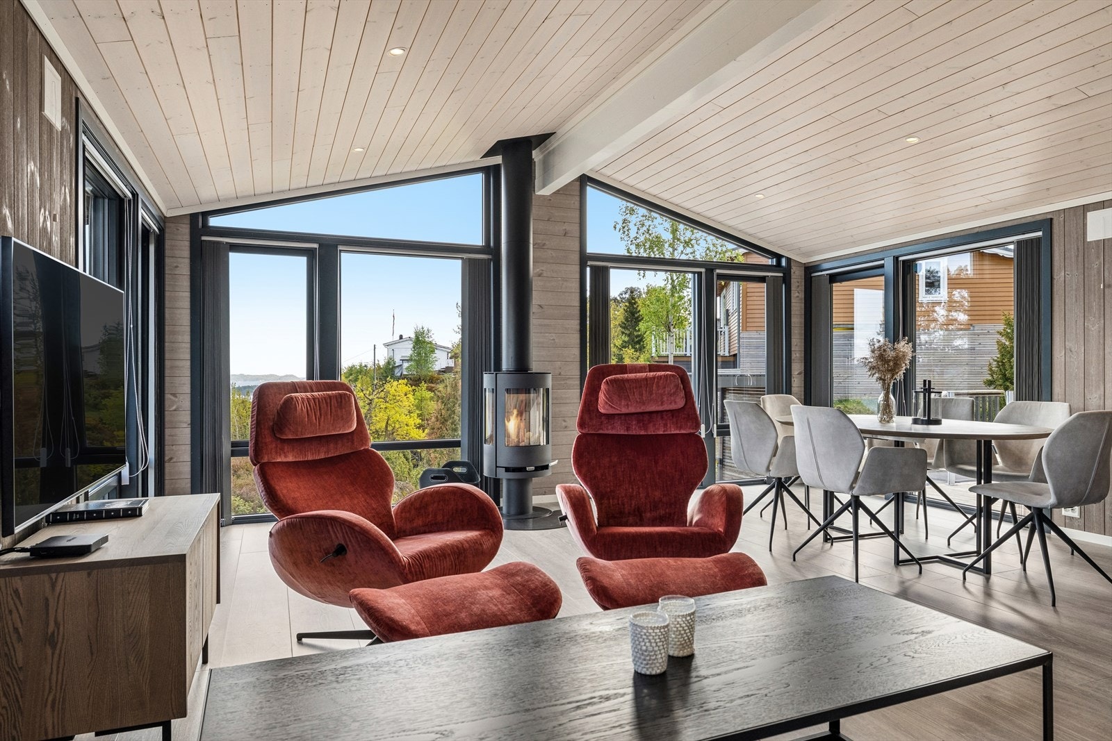 Stuen har plass til både sofagruppe og spisebord, med store vindusflater som slipper naturen inn. Galleribilde
