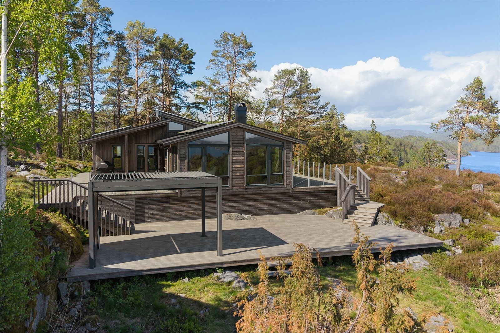 Hytta glir naturlig inn i det omkringliggende skogs- og kystlandskapet. Galleribilde