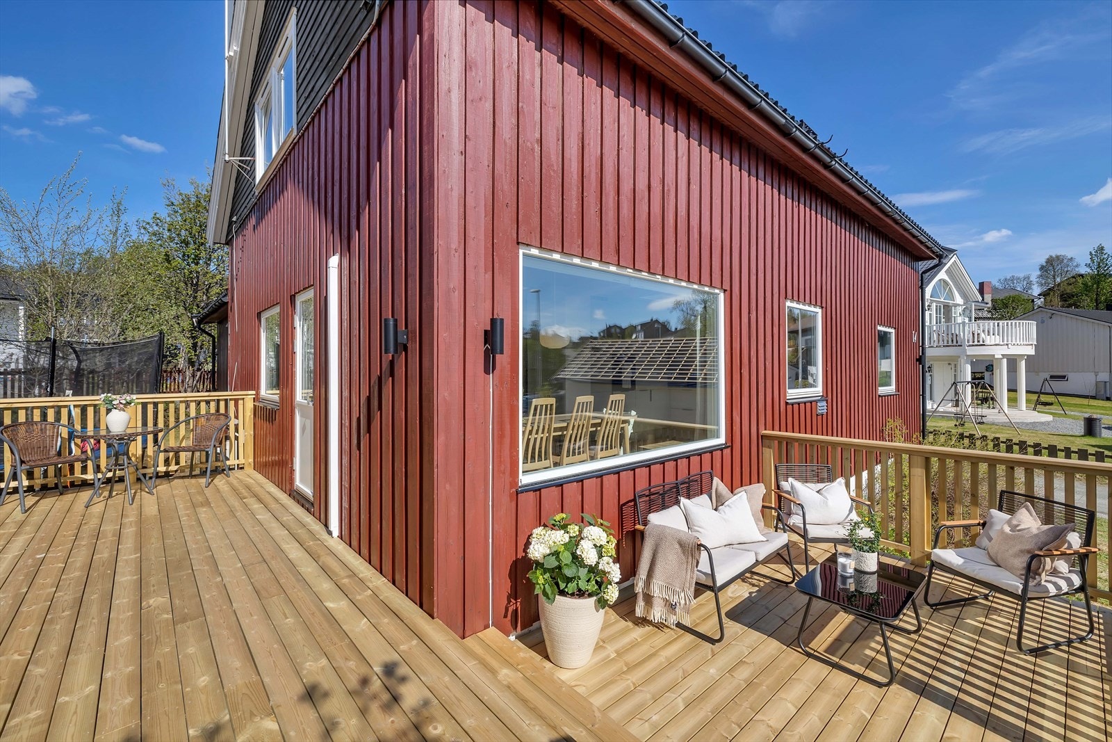 Terrasse bygget på to sider av huset - utgang fra stuen og trapp ned til uteareal Galleribilde