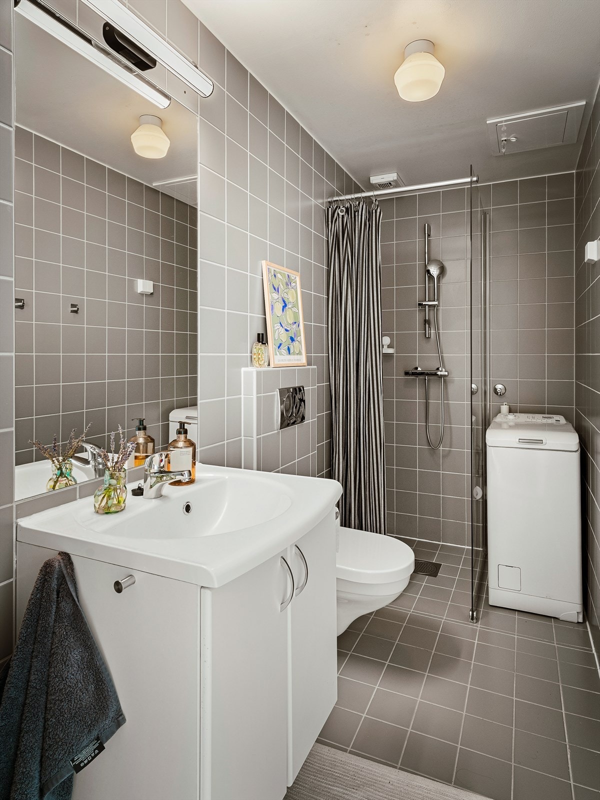 Badet har dusjhjørne med glassvegg og forheng, samt servant nedfelt i innredning. Galleribilde